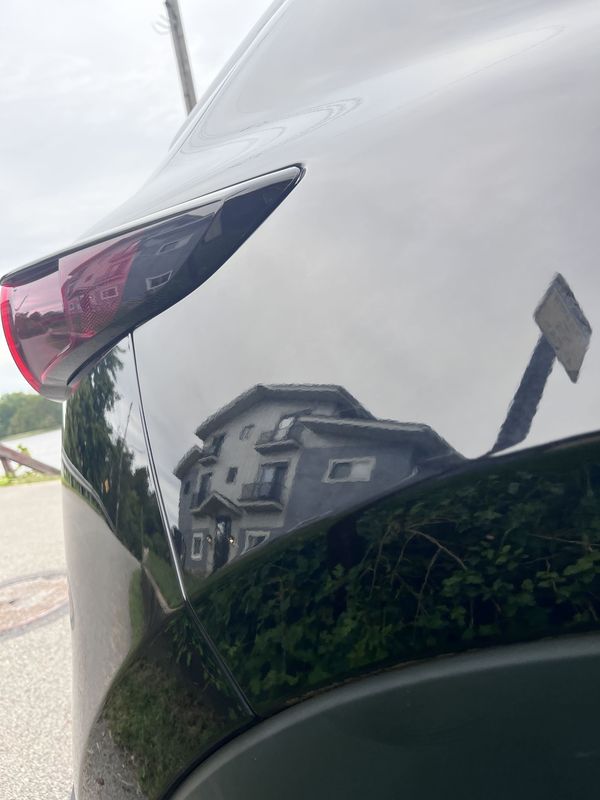 Rear quarter panel reflecting the street.