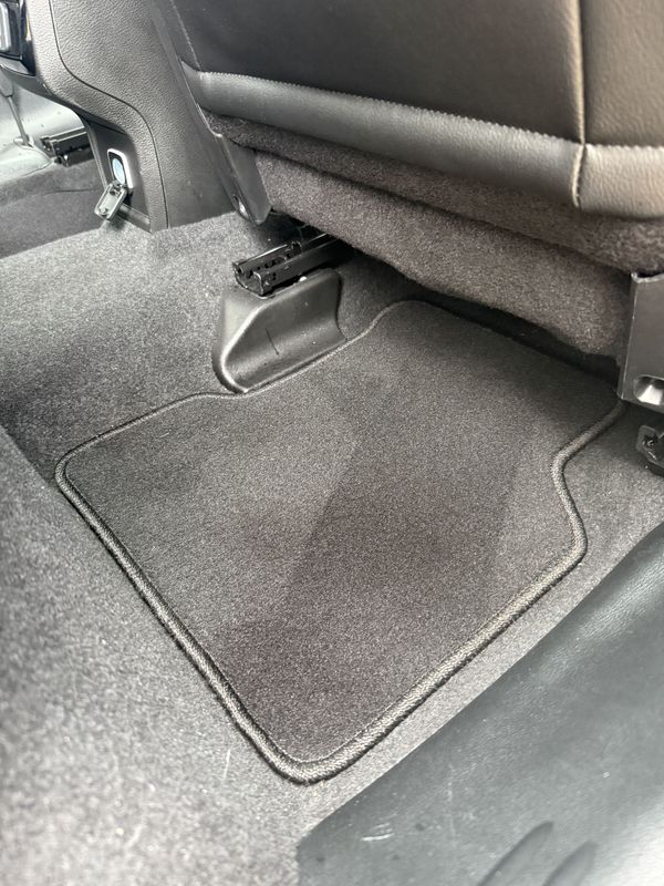 Rear floor mat and seat rails after vacuuming.