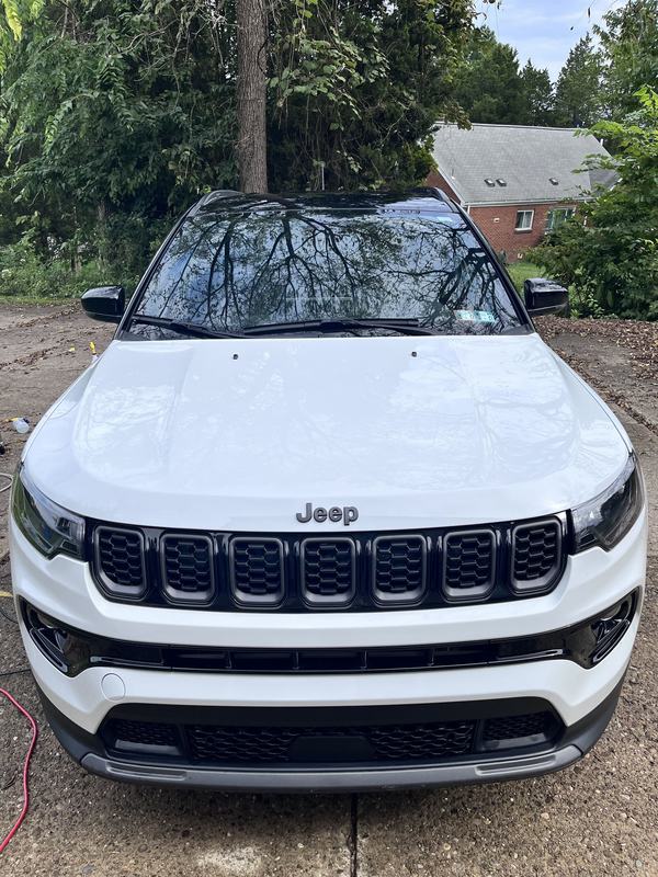 Front of the Jeep straight on, clean and dry, parked in the driveway.