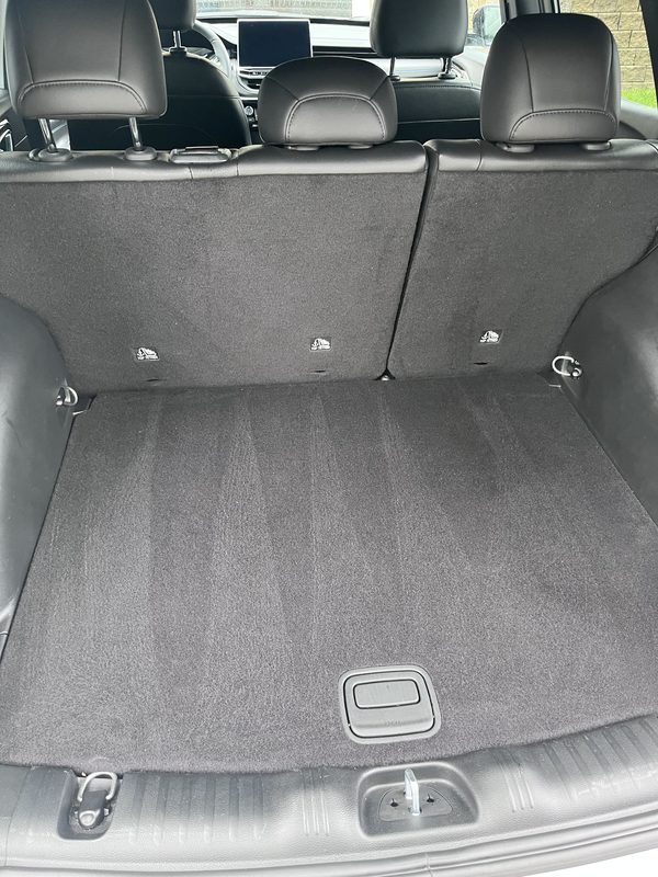 Cargo area seen from inside the trunk after vacuuming, with the rear seats folded down and visible.