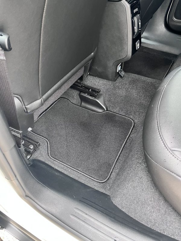Rear floor mat and seat rail area after vacuuming.