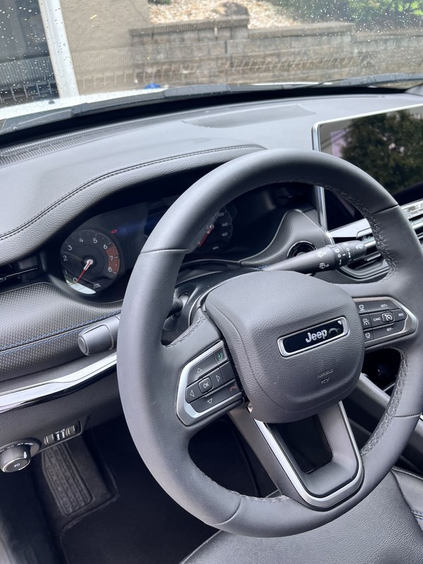 Steering wheel and dash with the Jeep badge, dust free after detailing.