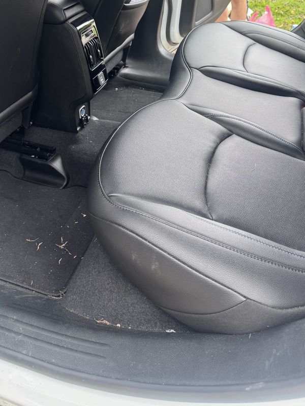 Rear seat and floor with debris before cleaning.